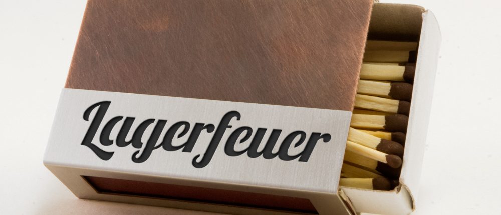 Streichholzschachtel - Huelle "Lagerfeuer" aus Kupfer und Edelstahl mit schwarzer Schrift Streichholzschachtel - Huelle "Lagerfeuer" aus Kupfer und Edelstahl mit schwarzer Schrift