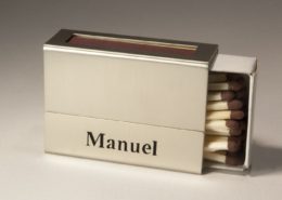 Eine Streichholzschachtel-Hülle mit dem ausgesägten Namen "Manuel"